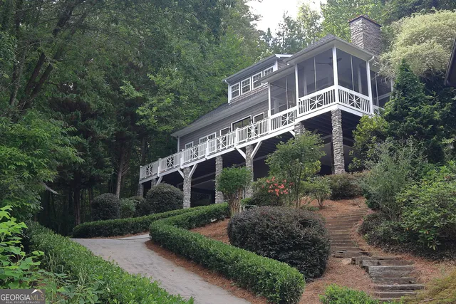 a front view of a house with a yard and large trees