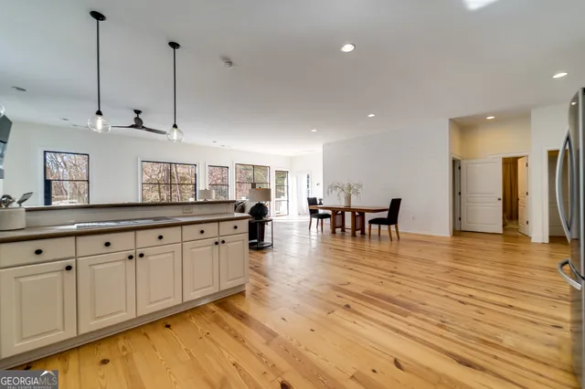 a view of a kitchen with kitchen island granite countertop wooden floors and a view of living room