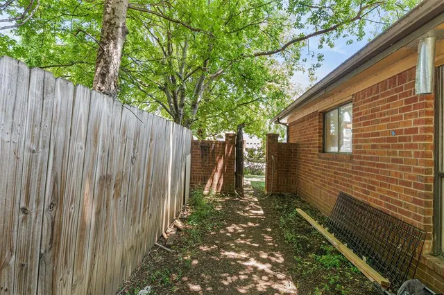 a view of a backyard with wooden fence