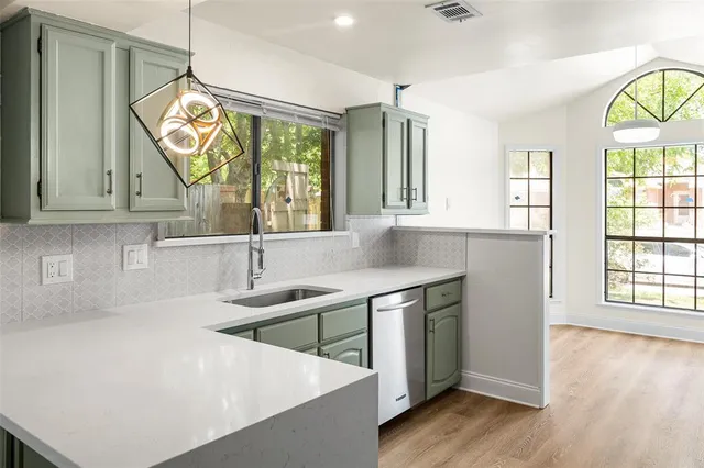 a kitchen with stainless steel appliances a sink a stove and a large window