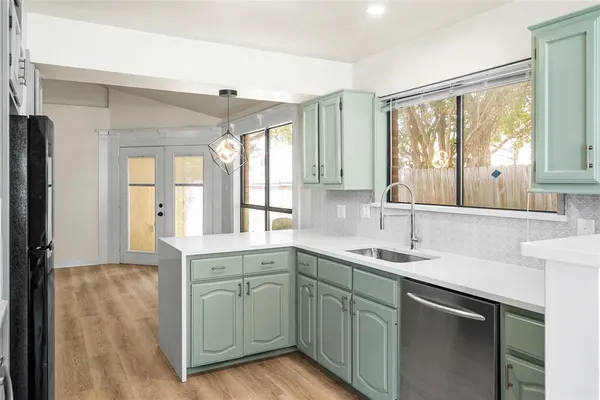 a kitchen with a sink window and cabinets