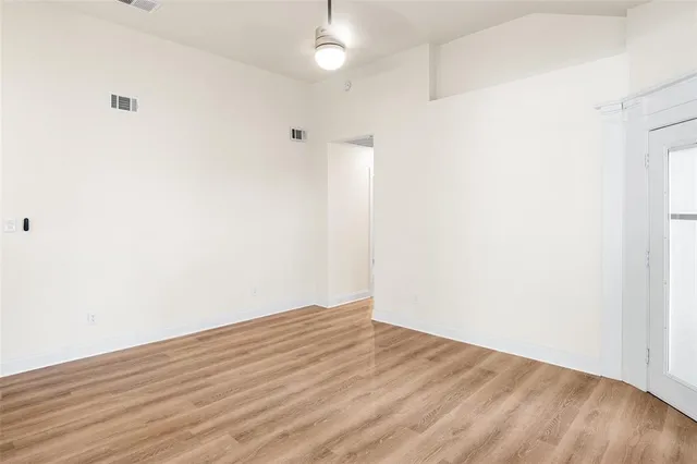 a view of empty room with wooden floor