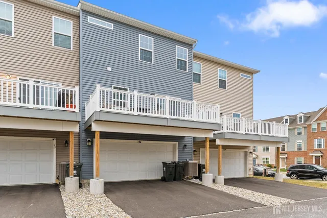 a large white kitchen with kitchen island a stove a sink a refrigerator and white cabinets with wooden floor