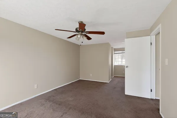 a view of a livingroom with a ceiling fan and refrigerator