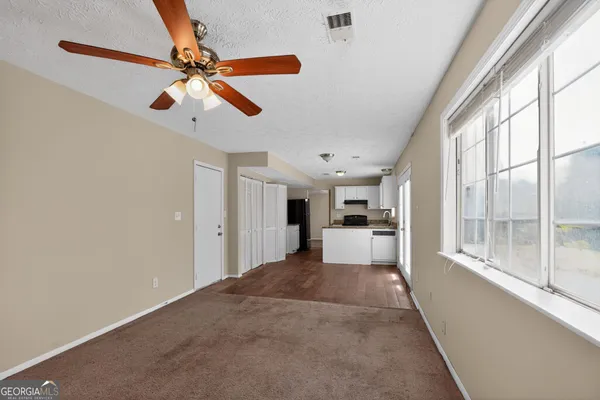 a view of a living room with a ceiling fan and window