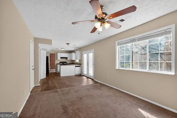 a view of a livingroom with a ceiling fan and windows