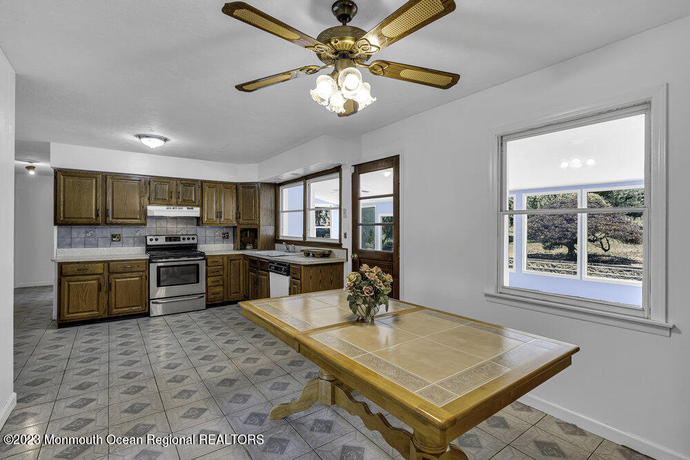 77 Farrington Road Old Bridge, NJ 07747 - Photo 15 of 33 a kitchen with stainless steel appliances granite countertop a sink a stove a refrigerator cabinets and chairs