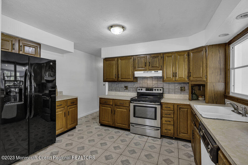 77 Farrington Road Old Bridge, NJ 07747 - Photo 16 of 33 a kitchen with stainless steel appliances granite countertop a stove top oven a sink dishwasher and a refrigerator