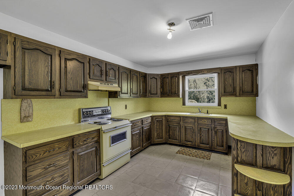 77 Farrington Road Old Bridge, NJ 07747 - Photo 23 of 33 a kitchen with stainless steel appliances granite countertop a stove a sink dishwasher and a microwave oven with cabinets