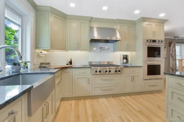 a kitchen with stainless steel appliances a sink stove and cabinets