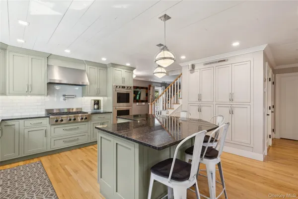 a kitchen with stainless steel appliances granite countertop a stove a sink dishwasher a refrigerator with a dining table and chairs