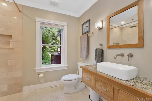 a bathroom with a granite countertop sink toilet and mirror