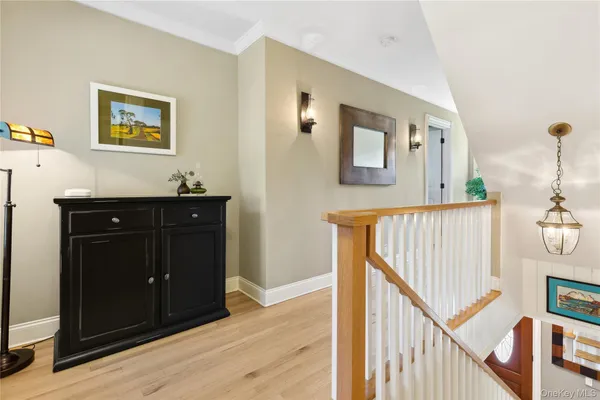 a view of a hallway with wooden floor and stairs