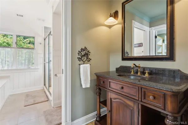 a bathroom with a granite countertop sink a mirror and a shower