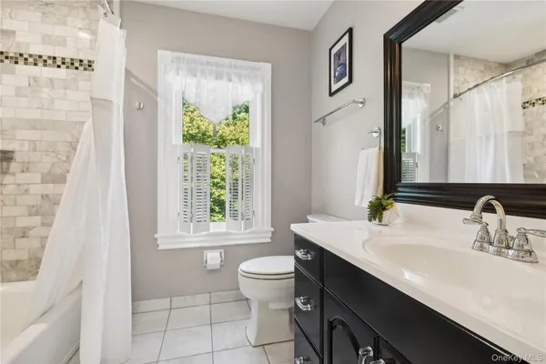 a bathroom with a granite countertop sink toilet and mirror