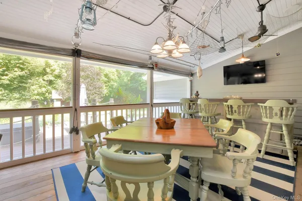a view of a dining room with furniture a chandelier and wooden floor