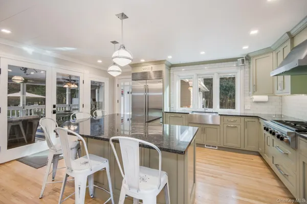 a kitchen with stainless steel appliances granite countertop a stove top oven a dining table and chairs