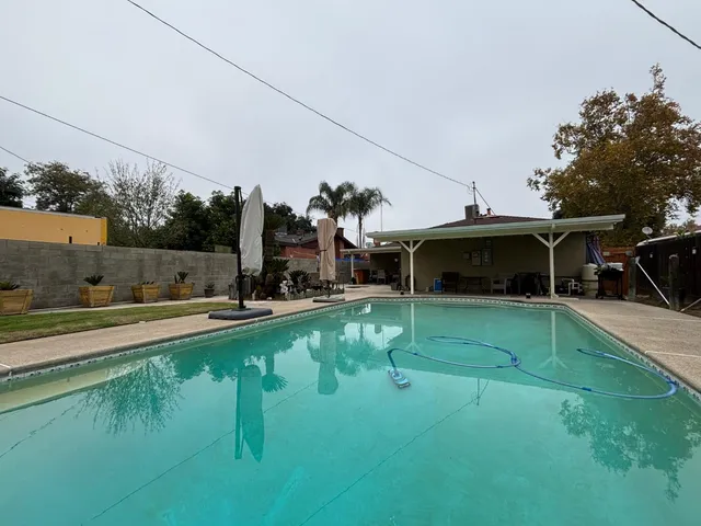 a view of a swimming pool with a yard and sitting area