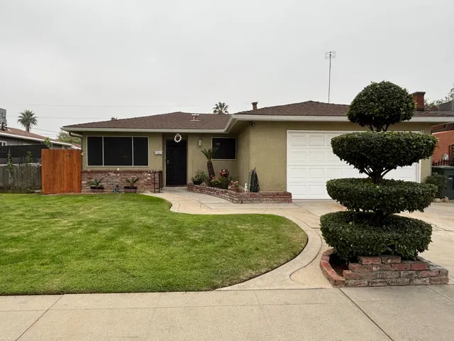 a view of a house with backyard and sitting area