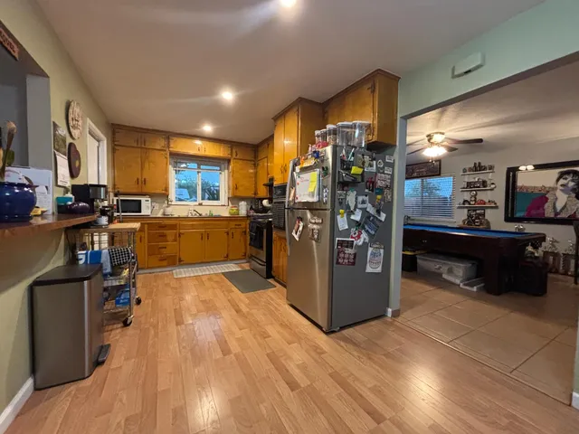 a kitchen with stainless steel appliances kitchen island granite countertop a refrigerator a stove top oven a sink and dishwasher