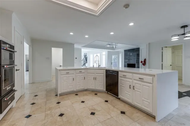 a large white kitchen with cabinets