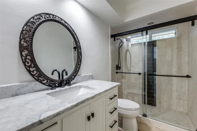 a bathroom with a sink mirror toilet and shower