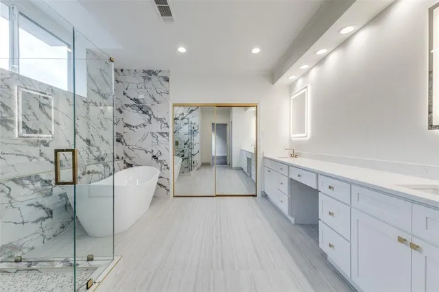 a spacious bathroom with a double vanity sink a mirror and a bathtub