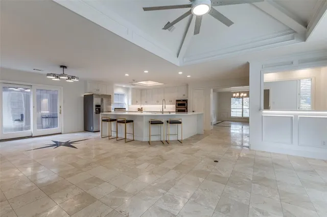 a view of kitchen with kitchen island stainless steel appliances refrigerator oven and cabinets