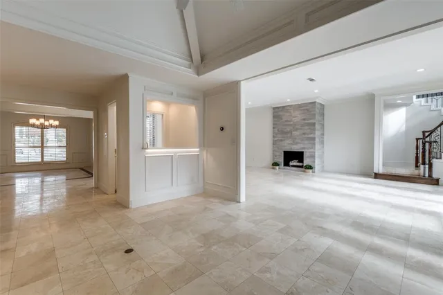 an empty room with windows and fireplace