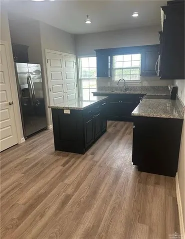 a kitchen with granite countertop a sink and a stove top oven