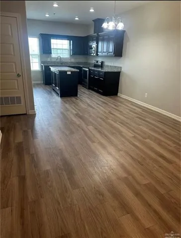 an open kitchen with a sink and dishwasher with a fireplace