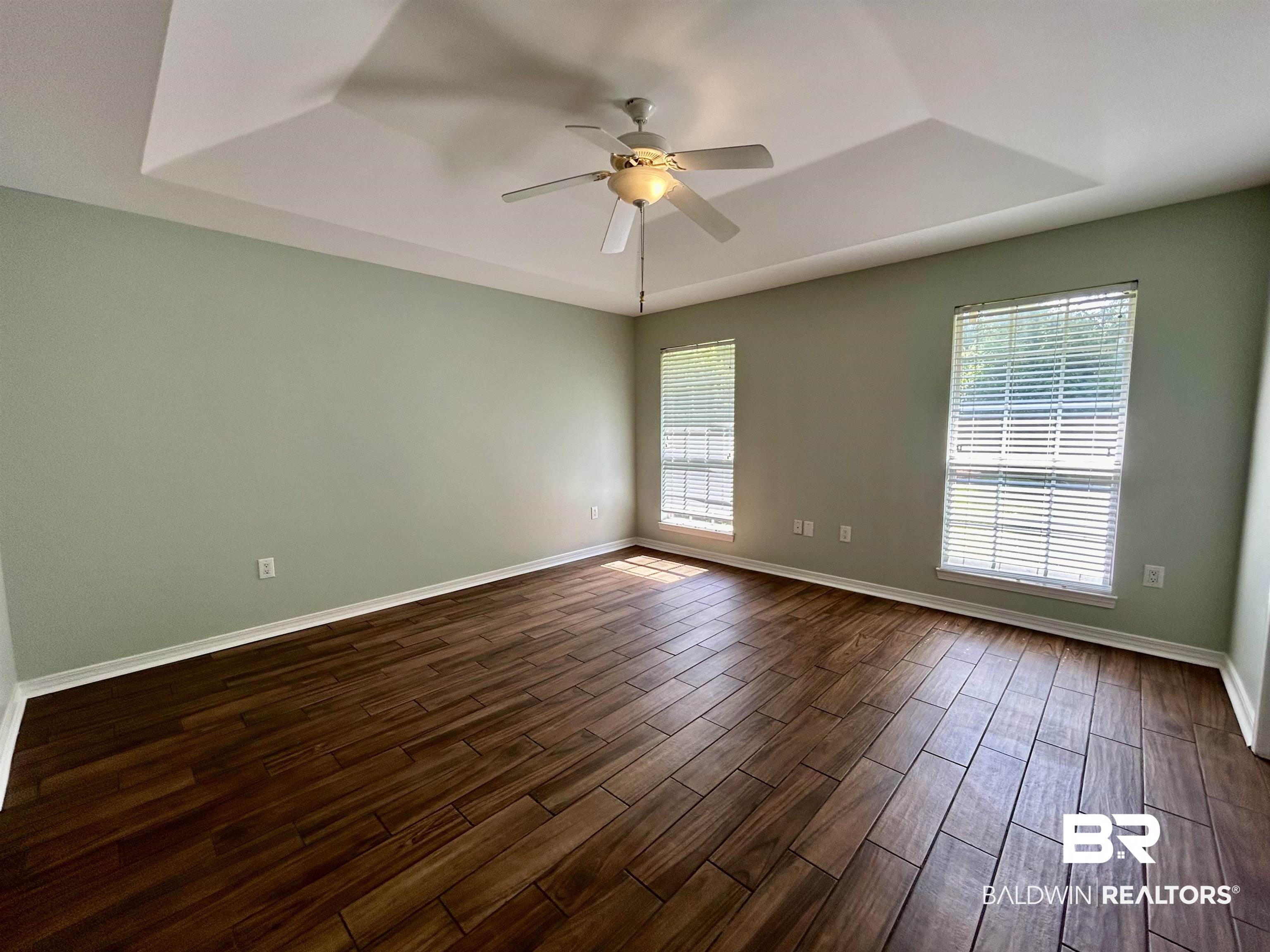 7198 Raintree Lane Gulf Shores, AL 36542 - Photo 11 of 33 Spacious room featuring wood-finish flooring, a tray ceiling, and a ceiling fan