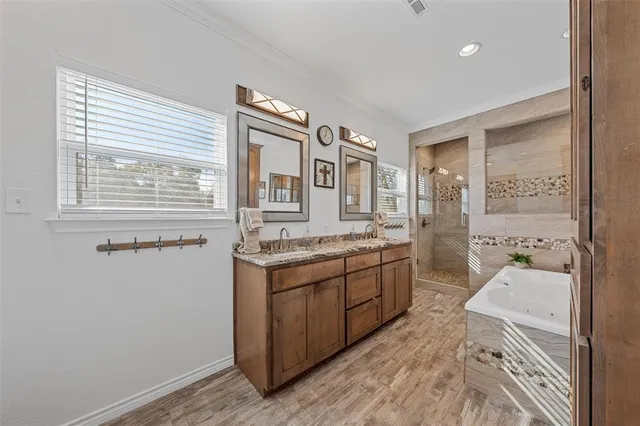 a spacious bathroom with a granite countertop sink a toilet a mirror and a tub