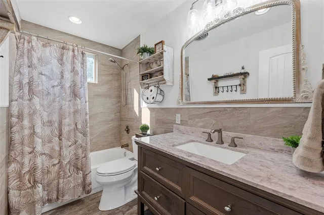 a bathroom with a granite countertop sink a toilet and a mirror