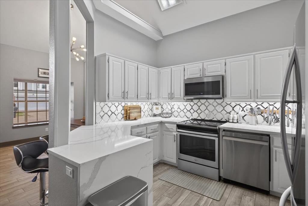 2934 North Bend Drive Dallas, TX 75229 - Photo 13 of 30 a kitchen with a stove a sink and a microwave