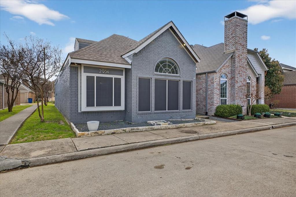 2934 North Bend Drive Dallas, TX 75229 - Photo 4 of 30 a view of a brick house with a yard plants next to a road