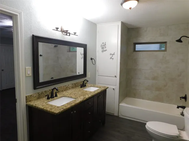 a bathroom with a sink vanity tub and toilet