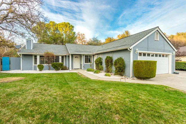 a view of a house with a garage and yard