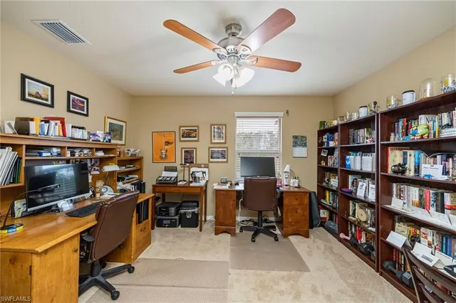 a view of a workspace with furniture and a bookshelf