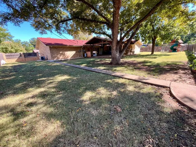 a view of a backyard with large trees