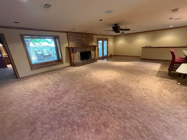 a view of an empty room with a fireplace and a window