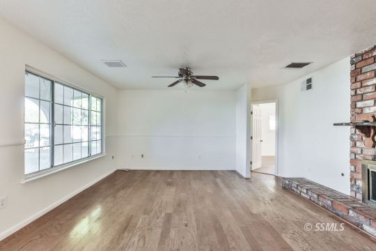 712 South Alvord Street Ridgecrest, CA 93555 - Photo 7 of 33 wooden floor in an empty room with a window