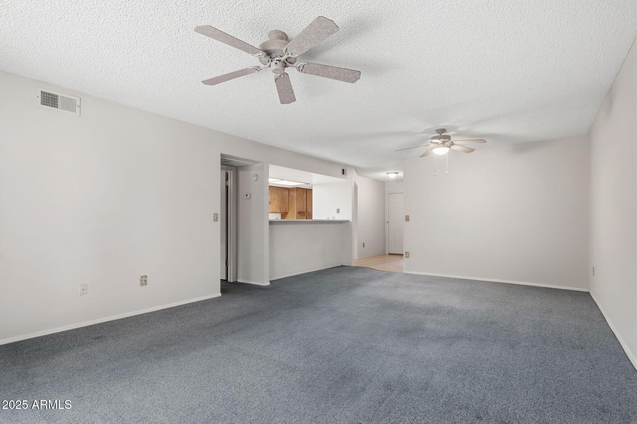 1021 South Greenfield Road, Unit 1148 Mesa, AZ 85206 - Photo 5 of 14 an empty room with chandelier fan and windows