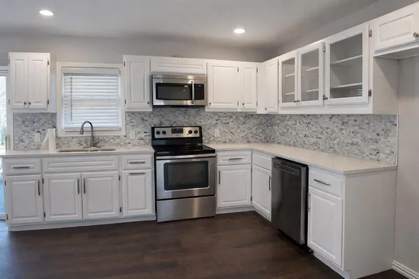 a kitchen with stainless steel appliances granite countertop a sink and a stove