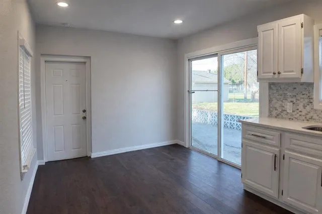 an empty room with wooden floor and a window