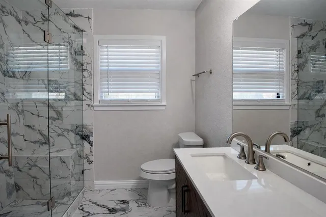 a bathroom with a sink a toilet and shower