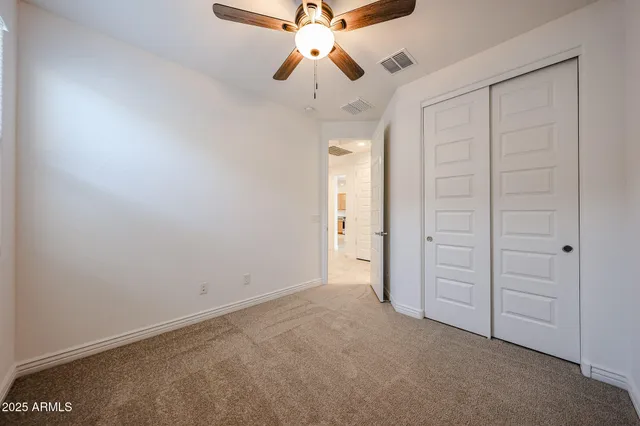 an empty room with chandelier fan