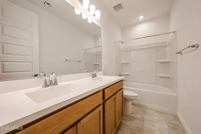 a bathroom with a sink a toilet a mirror and shower