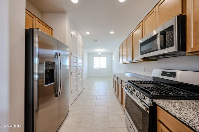a kitchen with stainless steel appliances granite countertop a stove a microwave and a refrigerator