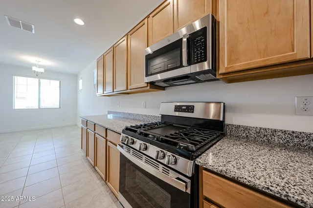 a kitchen with stainless steel appliances granite countertop a stove and a microwave